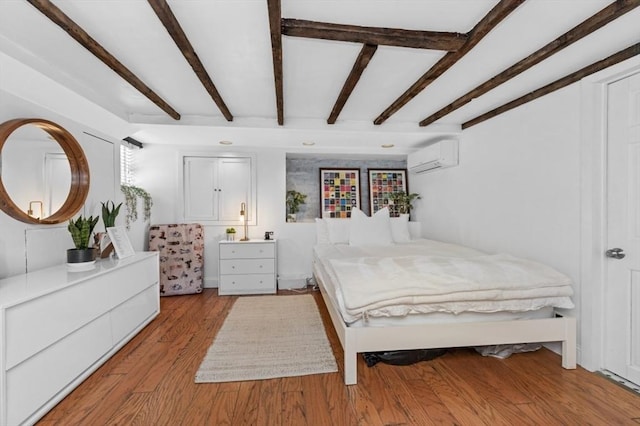 381 Bunker Hill St Unit 1, Boston, MA 02129 - bedroom with a wall unit AC, beamed ceiling, and light wood-style flooring