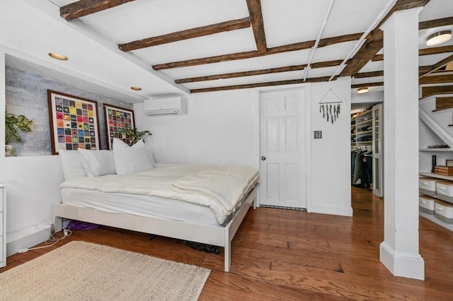 381 Bunker Hill St Unit 1, Boston, MA 02129 - bedroom with a wall unit AC, beamed ceiling, and wood finished floors
