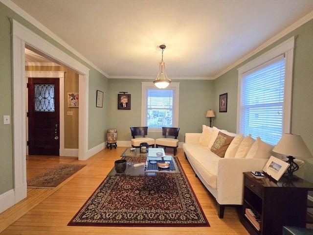 living room with light wood finished floors, ornamental molding, and baseboards