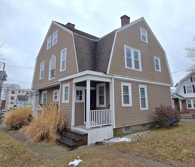 dutch colonial with a shingled roof, a chimney, and a gambrel roof