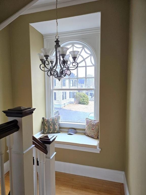 details with baseboards, wood finished floors, and a notable chandelier