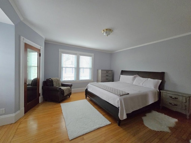 bedroom featuring ornamental molding, light wood-style flooring, and baseboards