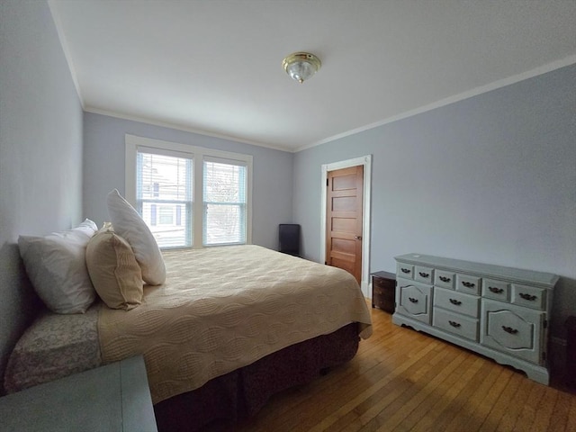 bedroom featuring light wood-type flooring and crown molding