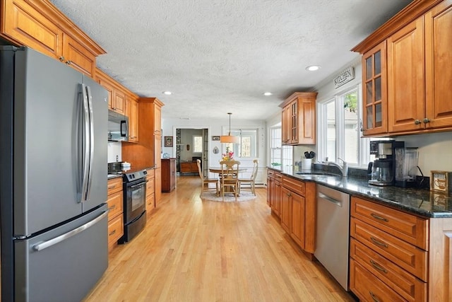 kitchen featuring recessed lighting, light wood finished floors, a sink, and black appliances
