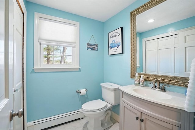 half bath featuring a baseboard heating unit, toilet, vanity, and baseboards