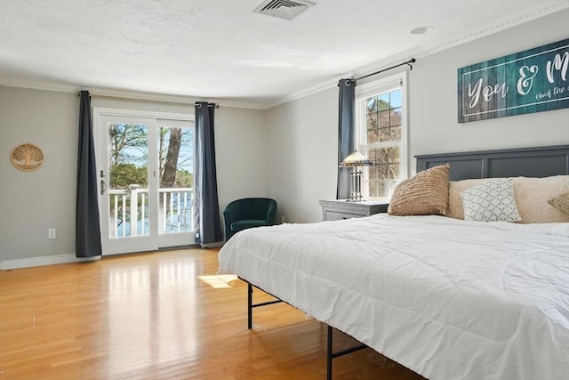 bedroom featuring wood finished floors, visible vents, crown molding, and access to exterior