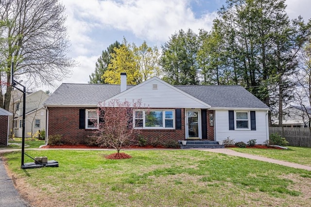 ranch-style home featuring a front lawn, a shingled roof, brick siding, a chimney, and fence