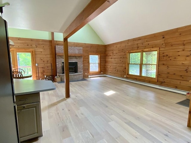 186 Hoosac Rd, Conway, MA 01341 - unfurnished living room featuring a baseboard radiator, wooden walls, plenty of natural light, a fireplace, and light wood-style flooring