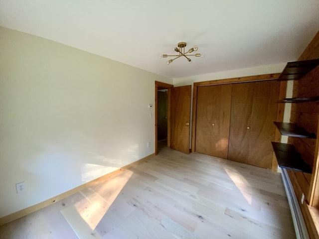 186 Hoosac Rd, Conway, MA 01341 - unfurnished bedroom with light wood-type flooring, a closet, baseboards, and a chandelier