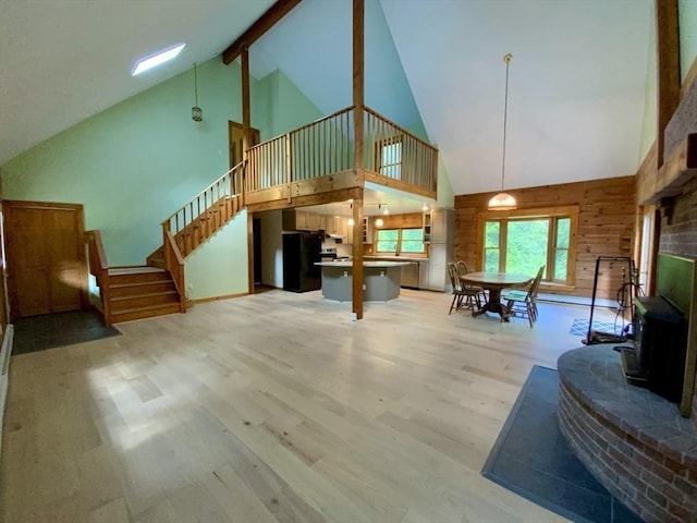 186 Hoosac Rd, Conway, MA 01341 - living room with high vaulted ceiling, wood finished floors, stairway, beam ceiling, and a wood stove
