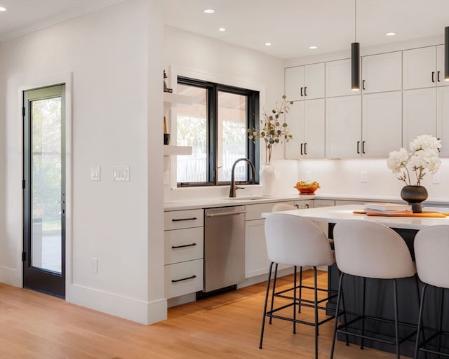 kitchen featuring dishwasher, a healthy amount of sunlight, white cabinetry, and sink