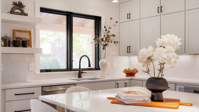 interior details with white cabinets, sink, and backsplash