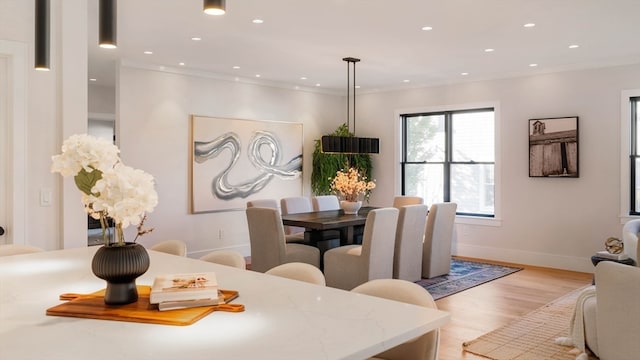 dining area featuring light hardwood / wood-style flooring and crown molding