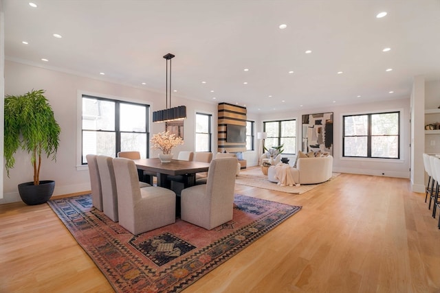 dining area featuring a wealth of natural light, light hardwood / wood-style flooring, and crown molding