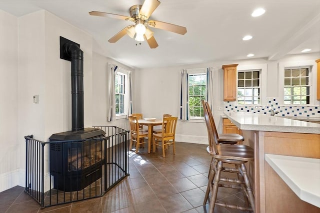 21 College Hill Rd, Somerville, MA 02144 - kitchen featuring a wood stove, light countertops, recessed lighting, light brown cabinets, and dark tile patterned floors