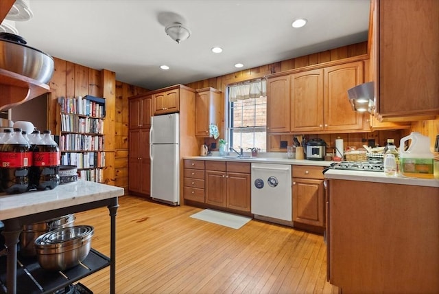 21 College Hill Rd, Somerville, MA 02144 - kitchen featuring white appliances, a sink, light countertops, light wood-style flooring, and wooden walls