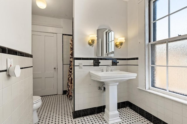 21 College Hill Rd, Somerville, MA 02144 - bathroom featuring tile walls, a wainscoted wall, toilet, and a shower with curtain