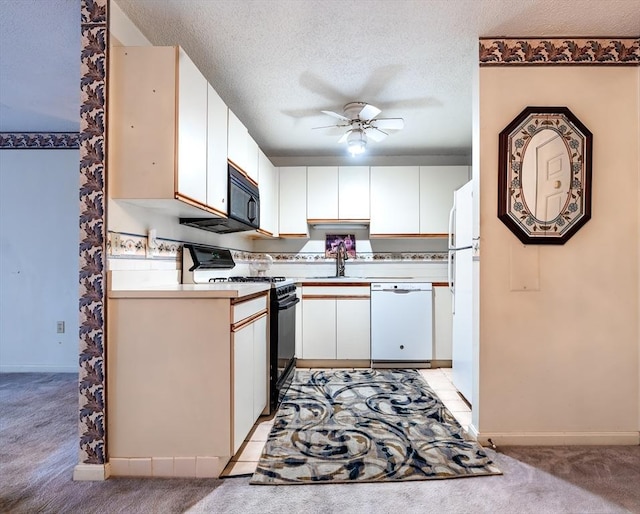 kitchen featuring white appliances, sink, light carpet, and white cabinets