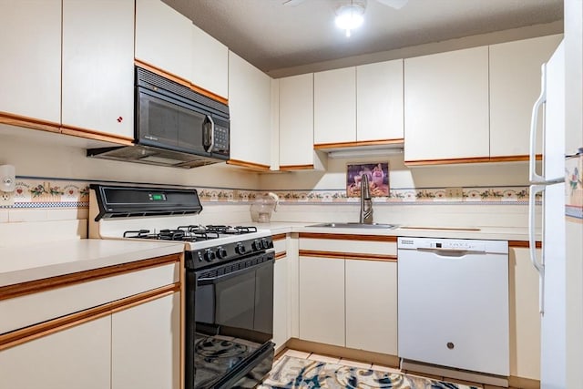 kitchen with sink, black appliances, white cabinets, and ceiling fan