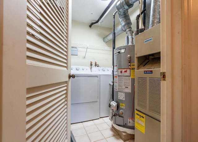 laundry area featuring washer and dryer, water heater, and light tile patterned flooring