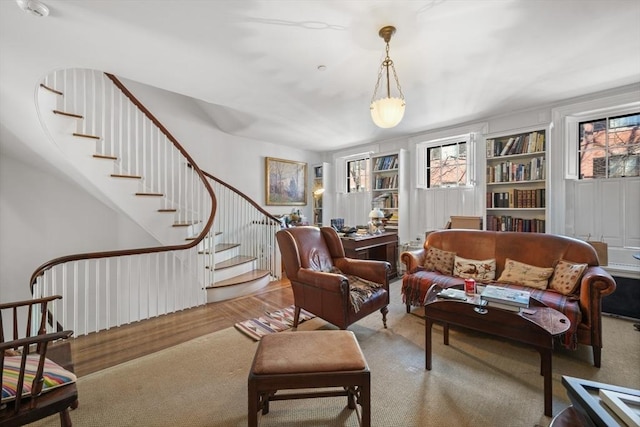 living room featuring stairs, built in features, and wood finished floors