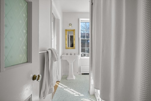 bathroom featuring a shower with curtain, baseboards, and tile patterned flooring