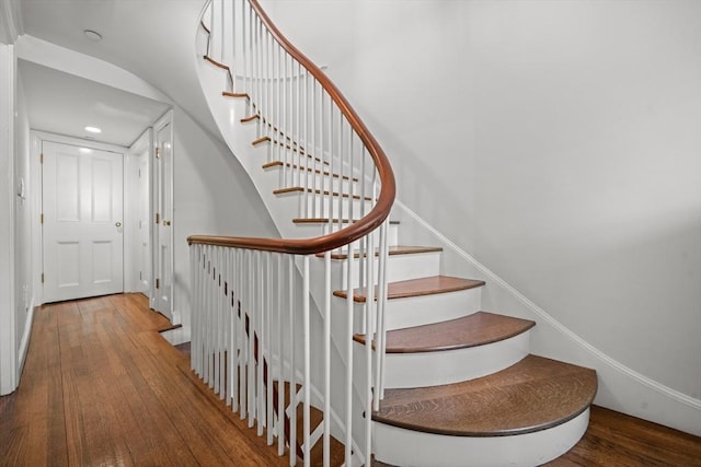 stairway with wood-type flooring and recessed lighting