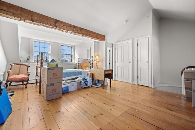 bedroom featuring light wood-style floors, multiple closets, vaulted ceiling, and a baseboard radiator