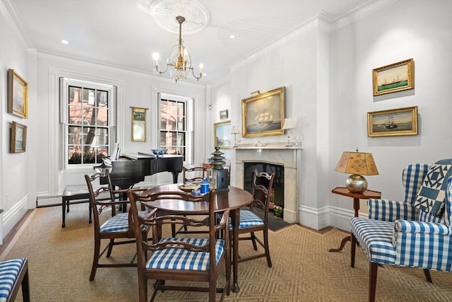 dining room featuring a high end fireplace, a chandelier, baseboards, crown molding, and recessed lighting