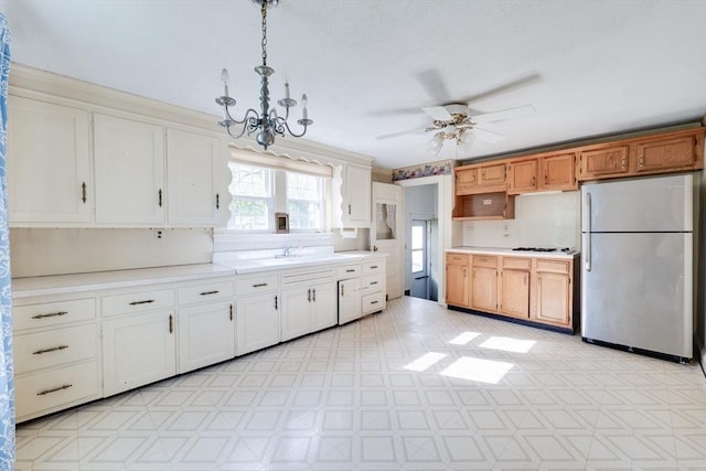 kitchen with freestanding refrigerator, light countertops, a ceiling fan, and light flooring