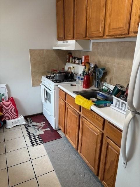 1117 Middlesex St, Lowell, MA 01851 - kitchen featuring white appliances, under cabinet range hood, light countertops, and decorative backsplash