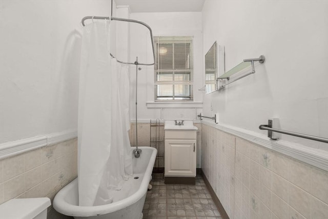 57 Rindge Ave, Cambridge, MA 02140 - bathroom with tile walls, a wainscoted wall, vanity, toilet, and shower / tub combo