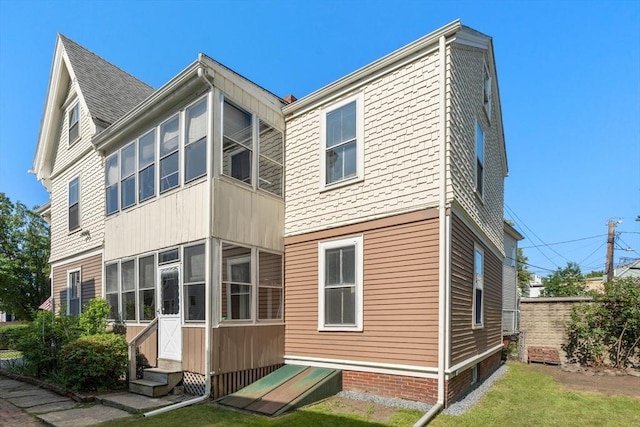 57 Rindge Ave, Cambridge, MA 02140 - back of property featuring entry steps, a sunroom, and a lawn