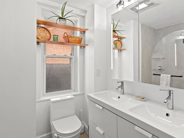 220-224 Washington St Unit 6, Brookline, MA 02445 - bathroom featuring visible vents, a sink, double vanity, and toilet