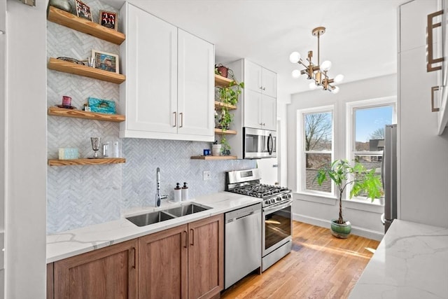 220-224 Washington St Unit 6, Brookline, MA 02445 - kitchen with appliances with stainless steel finishes, tasteful backsplash, open shelves, a sink, and a chandelier