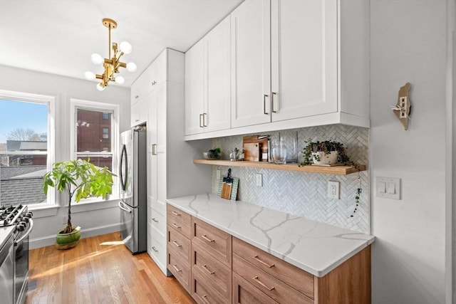 220-224 Washington St Unit 6, Brookline, MA 02445 - kitchen featuring appliances with stainless steel finishes, white cabinets, open shelves, and a chandelier