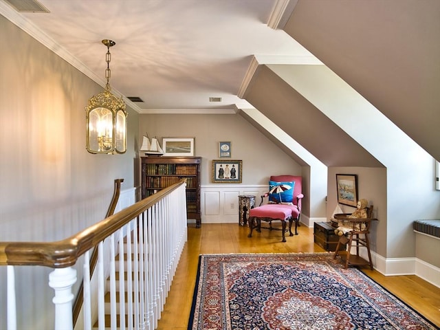 interior space with a chandelier, ornamental molding, and light hardwood / wood-style floors