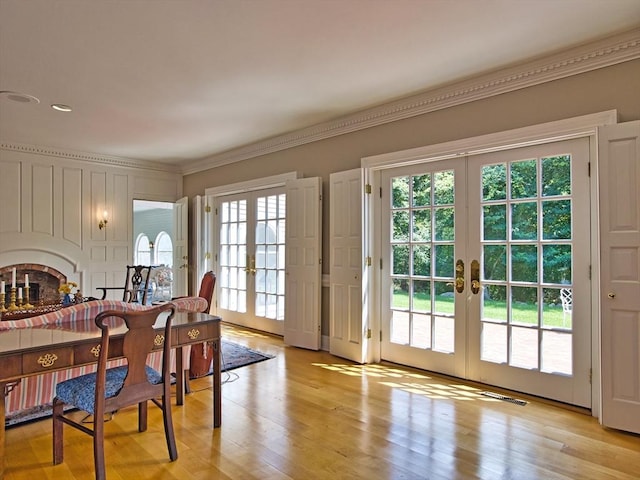 doorway to outside featuring light hardwood / wood-style flooring, crown molding, french doors, and a healthy amount of sunlight