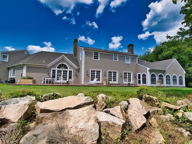 rear view of property with a lawn and french doors