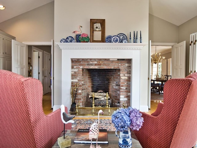 living room featuring a fireplace, an inviting chandelier, and vaulted ceiling