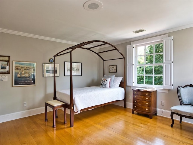 bedroom featuring crown molding and light wood-type flooring