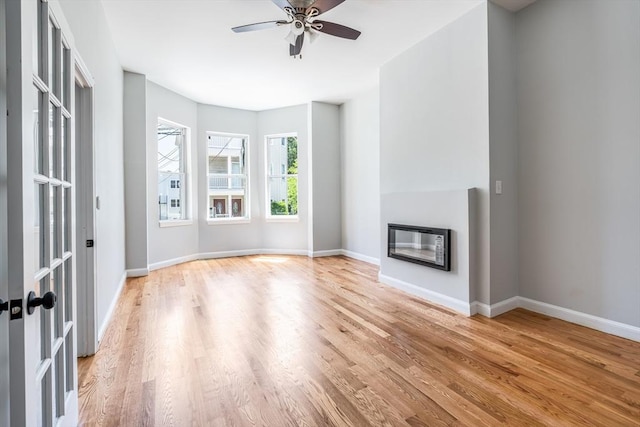 39 Mount Pleasant St, Somerville, MA 02145 - unfurnished living room featuring wood finished floors, a glass covered fireplace, and a ceiling fan