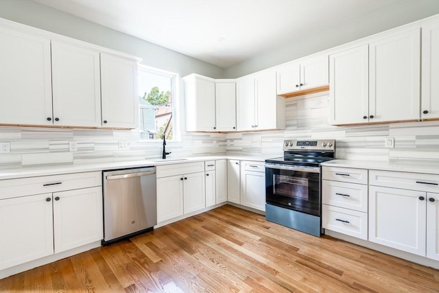 39 Mount Pleasant St, Somerville, MA 02145 - kitchen featuring stainless steel appliances, backsplash, light countertops, white cabinetry, and light wood finished floors