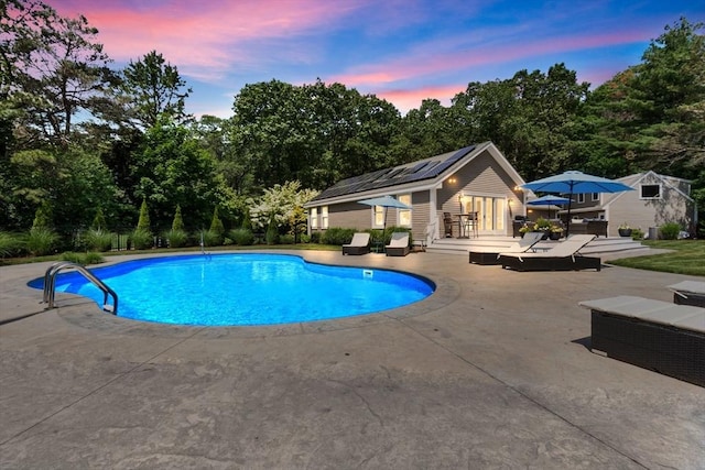 33 Pine Hill Rd, Newburyport, MA 01950 - pool at dusk with an outdoor pool, a patio, an outbuilding, a wooden deck, and view of wooded area