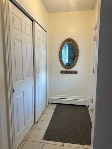 entryway with light tile patterned floors and a baseboard heating unit