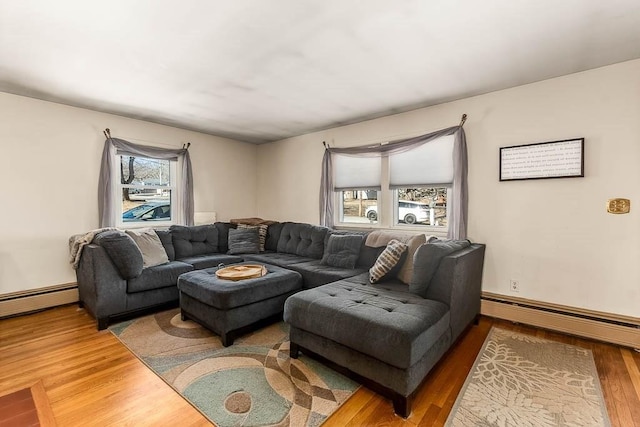 living room featuring a baseboard heating unit, a wealth of natural light, and wood finished floors