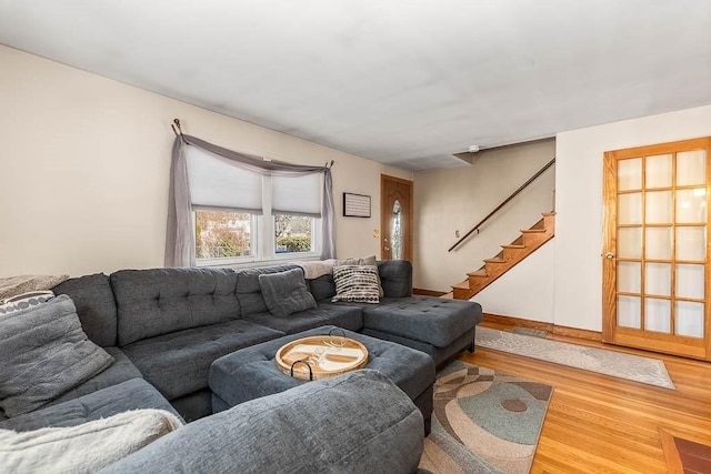 living area with stairs, wood finished floors, and baseboards