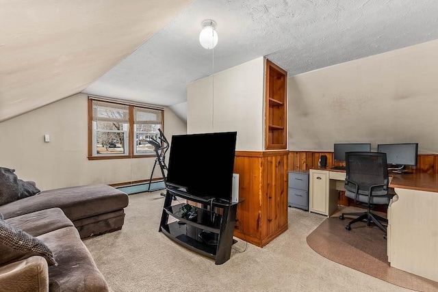 office space with lofted ceiling, light colored carpet, wainscoting, wooden walls, and a textured ceiling