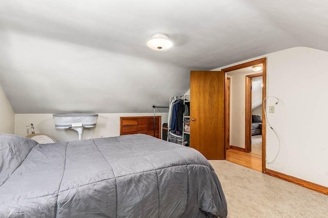 bedroom with lofted ceiling, carpet flooring, and baseboards