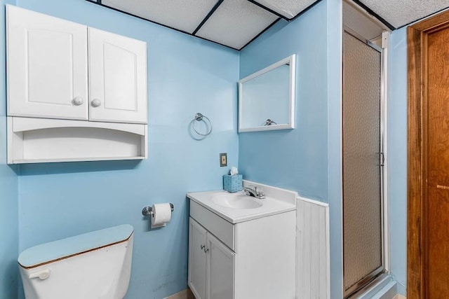 full bathroom with a drop ceiling, toilet, a shower stall, and vanity